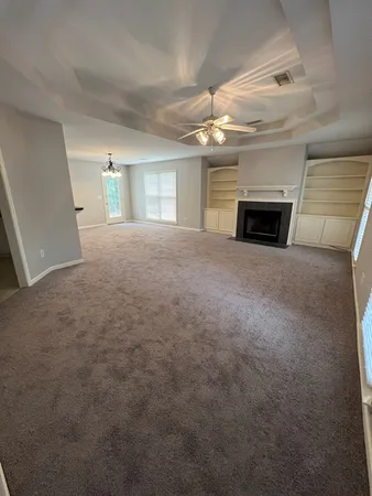 a view of empty room with fireplace and windows