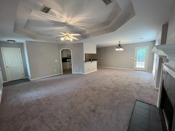 en empty room with windows and fireplace