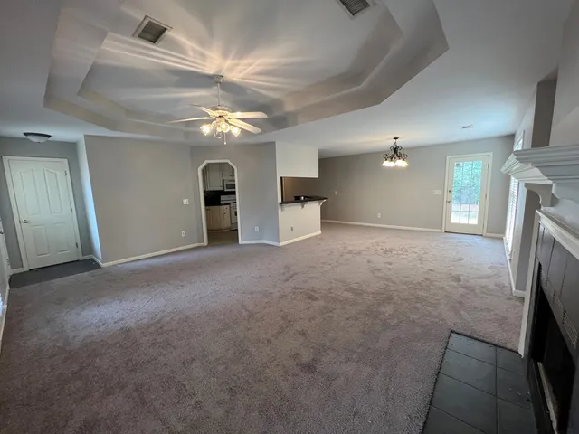 en empty room with windows and fireplace