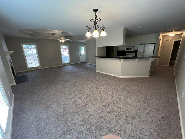 a view of a kitchen with a sink and chandelier