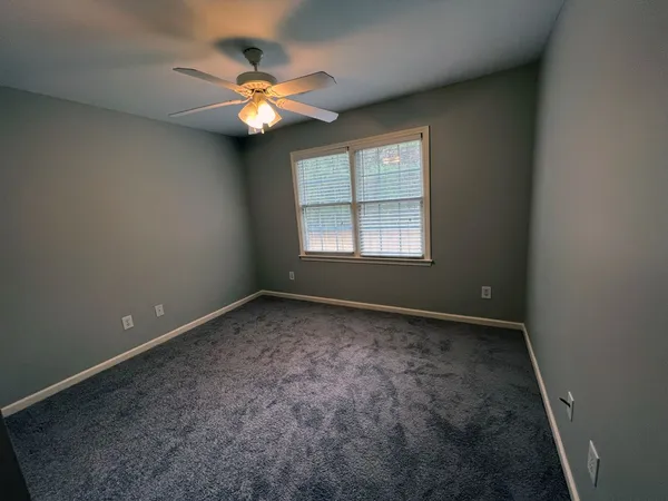 an empty room with window and fan