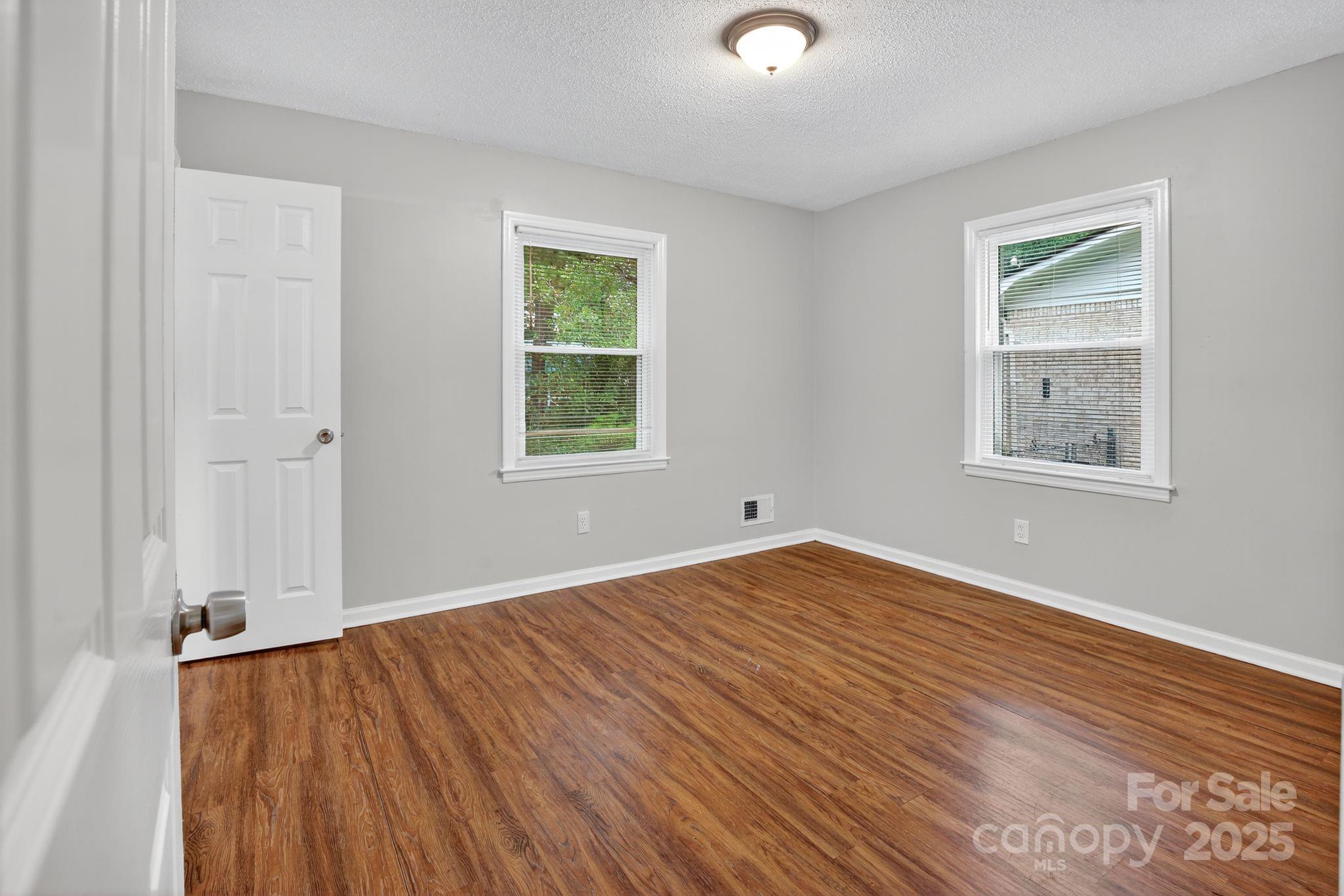 3725 Harrogate Road Columbia, SC 29210 - Photo 12 of 31 an empty room with wooden floor and windows