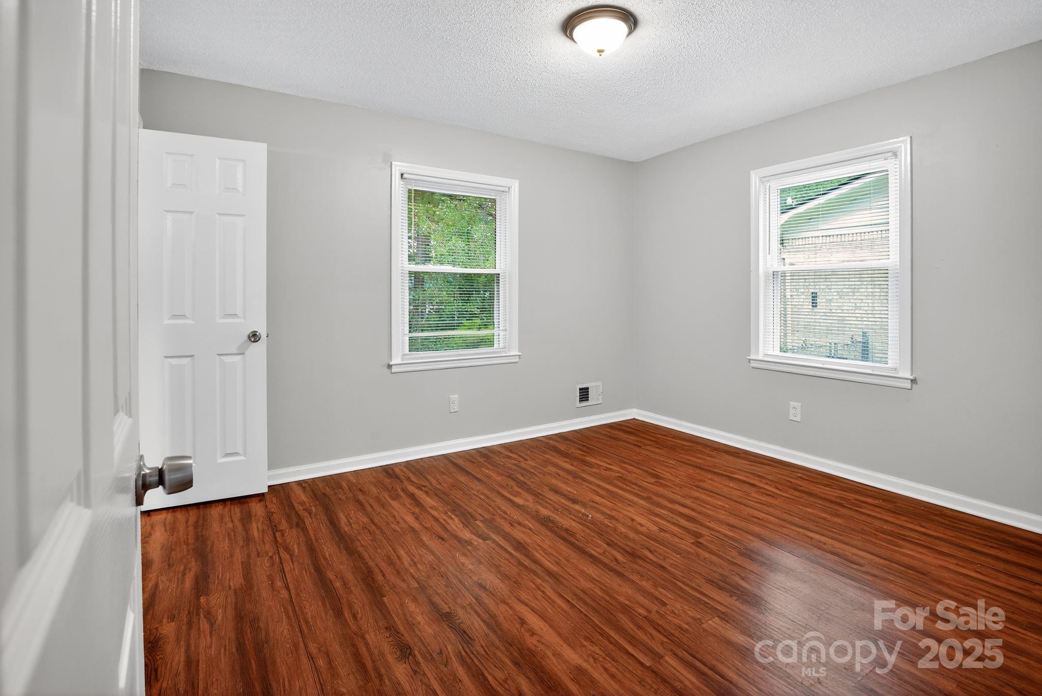 3725 Harrogate Road Columbia, SC 29210 - Photo 10 of 31 an empty room with wooden floor and windows