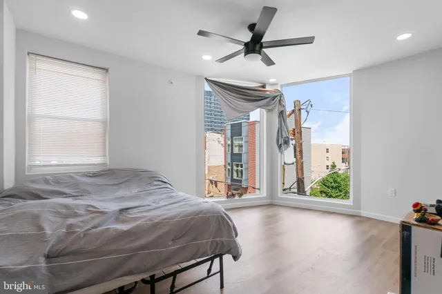 a bedroom with a bed and a large window