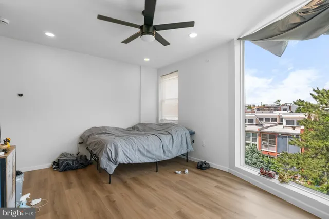 a living room with a bed furniture and a large window