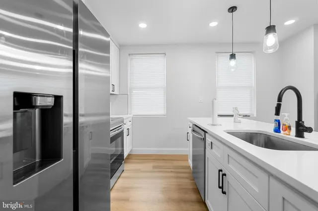 a kitchen with a refrigerator sink and cabinets
