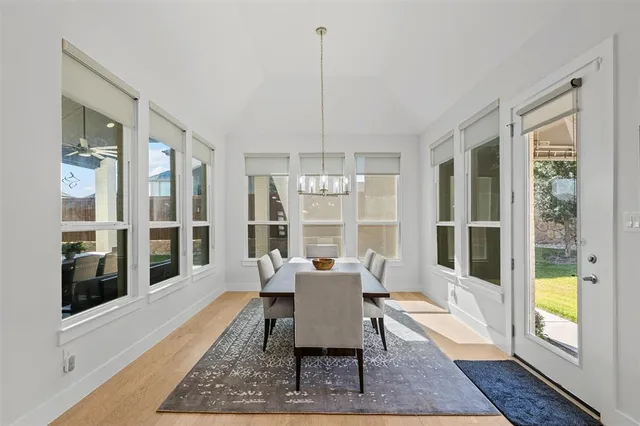 a dining room with furniture a chandelier and wooden floor