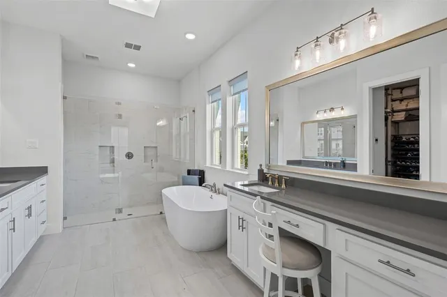 a spacious bathroom with a double vanity sink a mirror and a bathtub