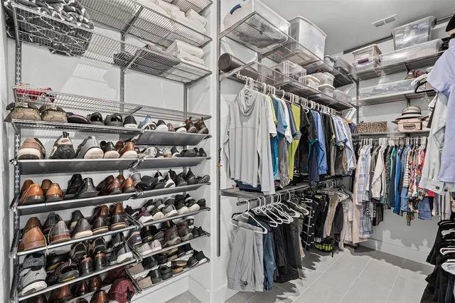 a view of walk in closet with clothes and shoes
