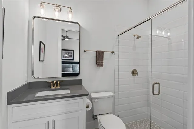 a bathroom with a granite countertop sink toilet and shower