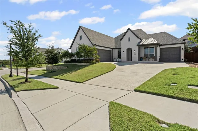 a front view of a house with a yard and potted plants