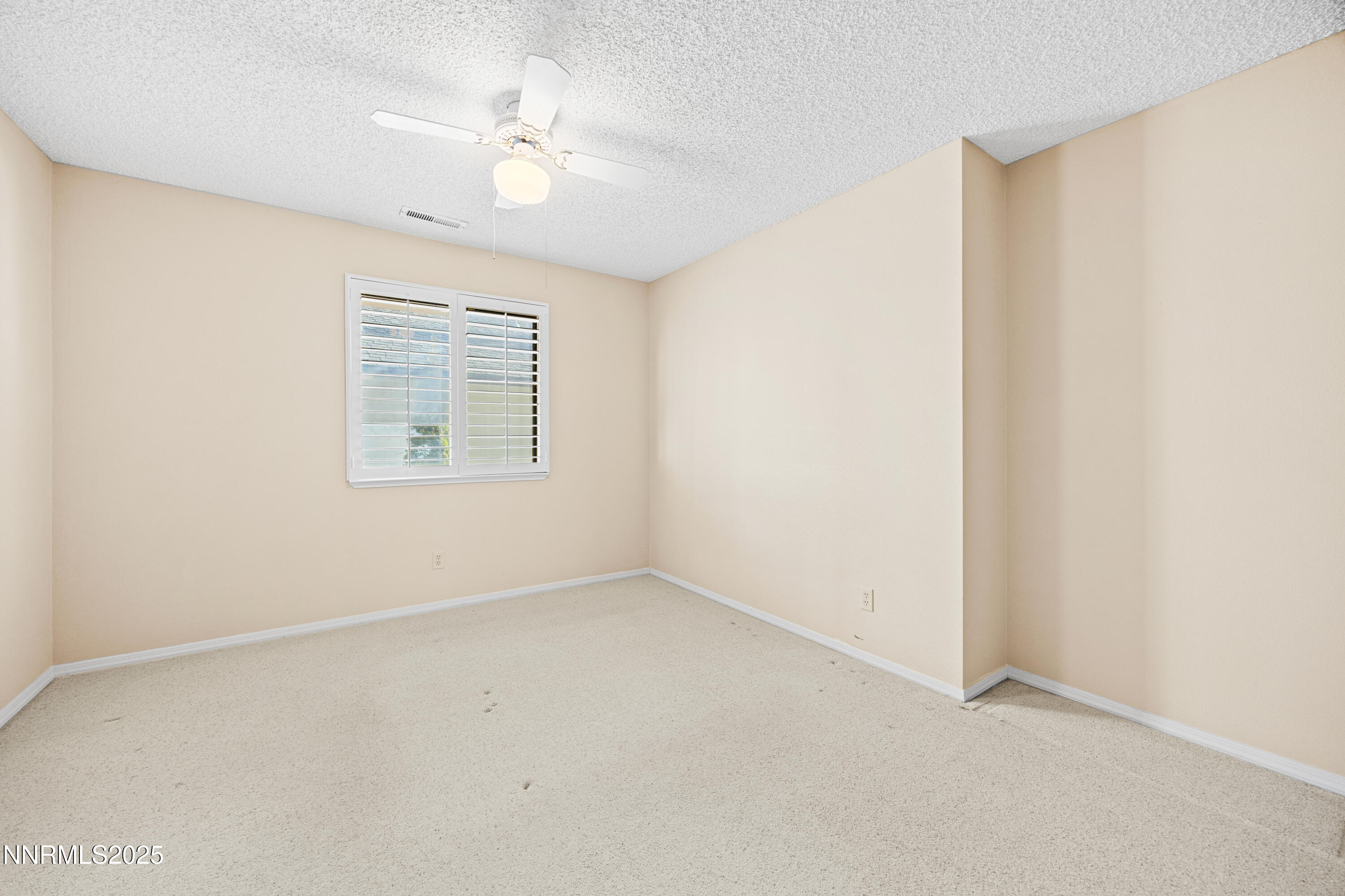 6299 Stone Valley Drive Reno, NV 89523 - Photo 37 of 70 an empty room with a window and a ceiling fan