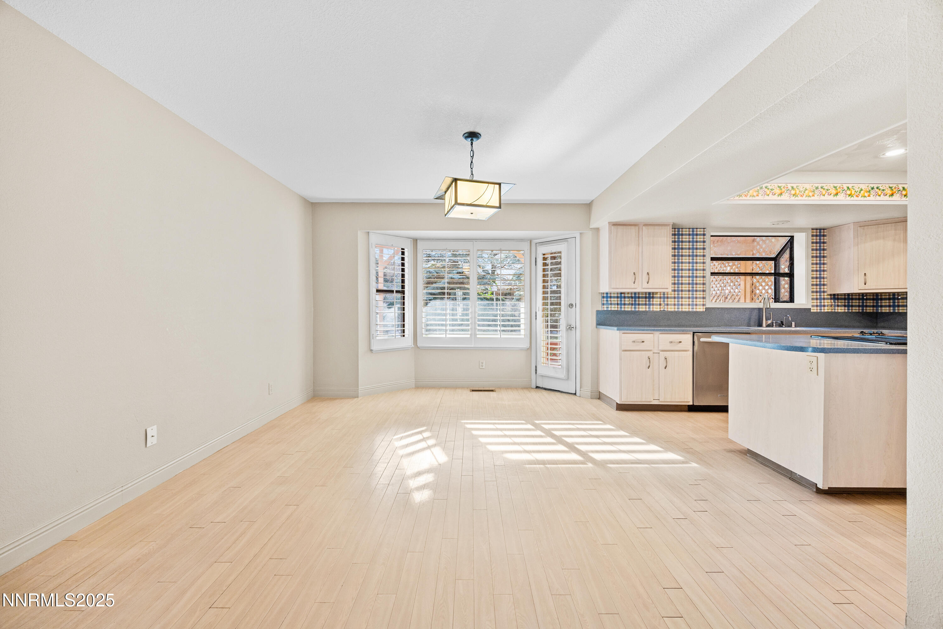 6299 Stone Valley Drive Reno, NV 89523 - Photo 8 of 70 a large white kitchen with granite countertop a stove a sink dishwasher and a refrigerator with wooden floor