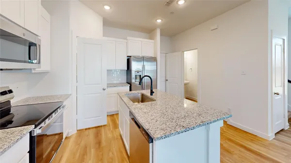 a kitchen with kitchen island granite countertop a sink and cabinets