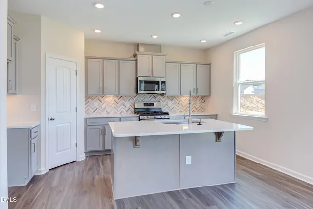 a kitchen with a sink cabinets and wooden floor