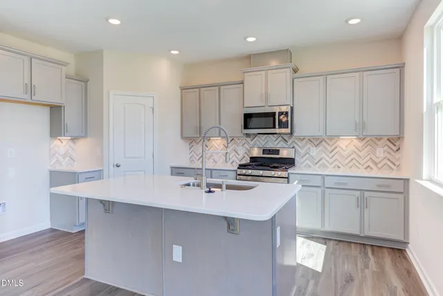 a kitchen with kitchen island white cabinets and stainless steel appliances