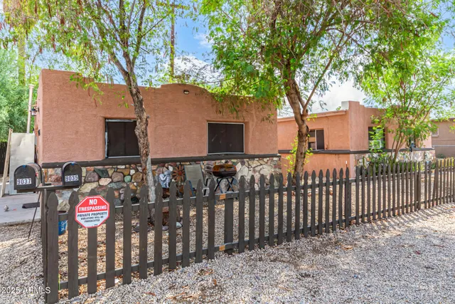 a view of a house with wooden fence