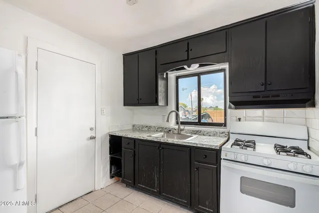 a kitchen with a sink stove and cabinets