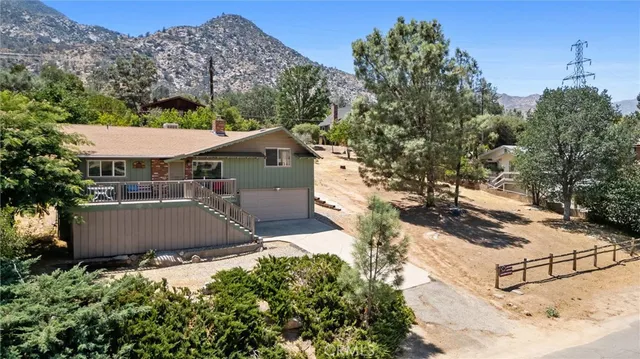 an aerial view of a house with a yard and lake view