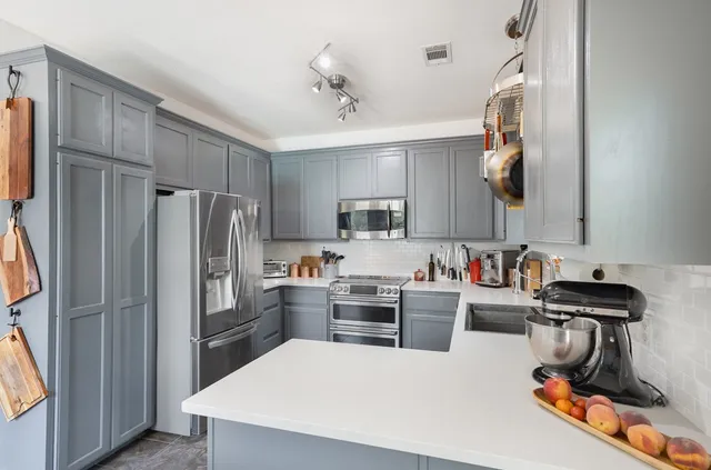 a kitchen with a refrigerator a sink dishwasher and a stove with wooden floor