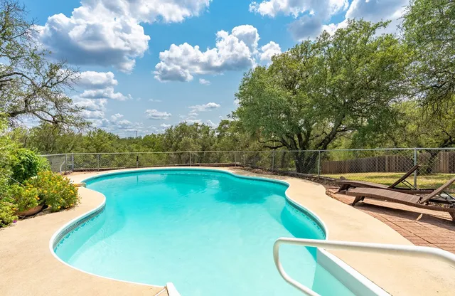a view of a swimming pool with a yard and sitting area