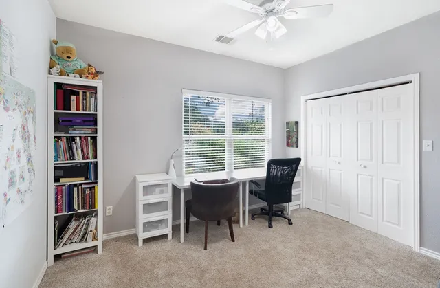 a view of a workspace with furniture and a window