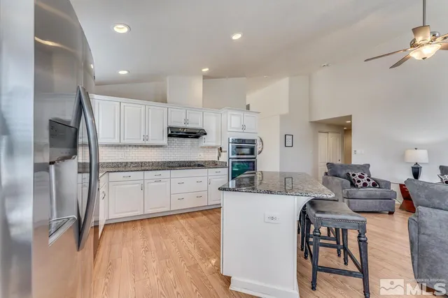 a kitchen with stainless steel appliances granite countertop a stove refrigerator sink and cabinets
