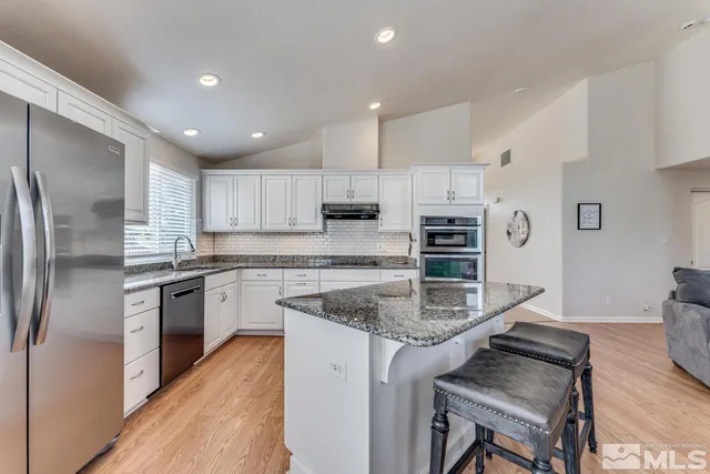 a kitchen with stainless steel appliances granite countertop a stove refrigerator sink and microwave
