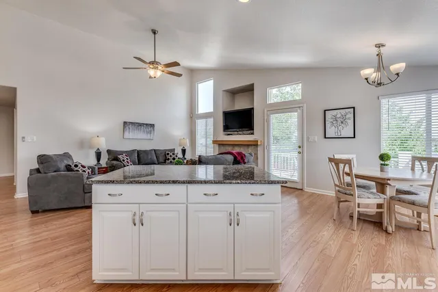 a living room with granite countertop furniture a fireplace and a flat screen tv