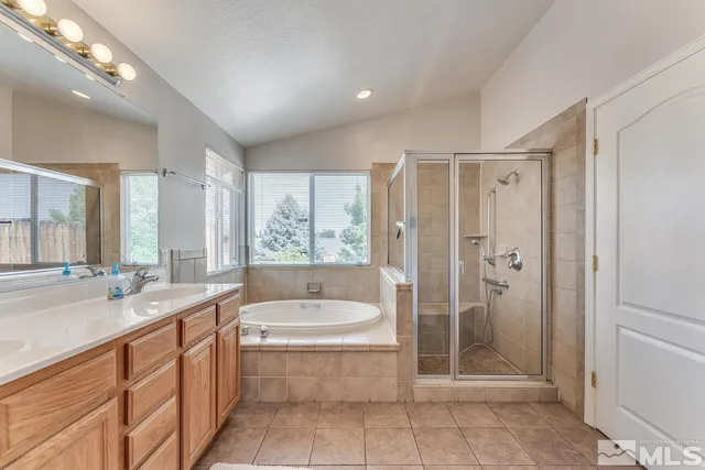 a spacious bathroom with a tub sink shower and mirror