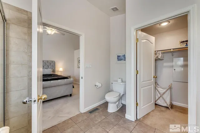 a spacious bathroom with a granite countertop toilet a sink and a mirror