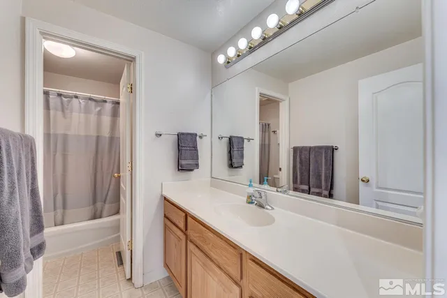 a bathroom with a double vanity sink a toilet and shower