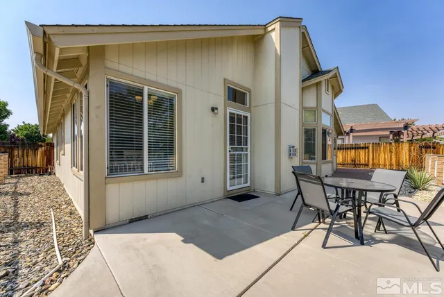 a backyard of a house with table and chairs
