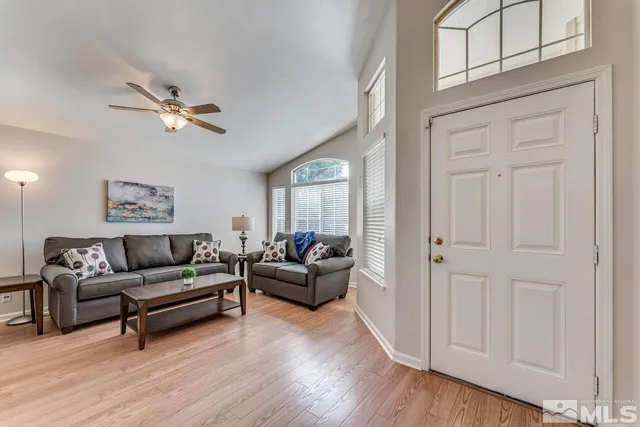 a living room with furniture ceiling fan and a wooden floor