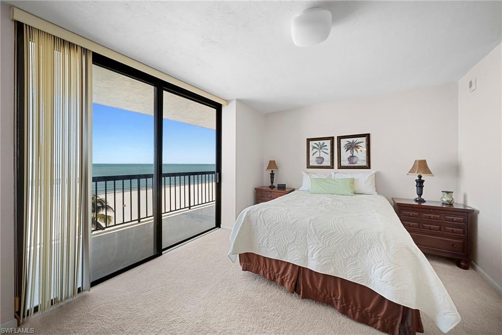 26300 Hickory Boulevard, Unit 503 Bonita Springs, FL 34134 - Photo 22 of 50 Bedroom with a water view, light colored carpet, access to outside, and floor to ceiling windows