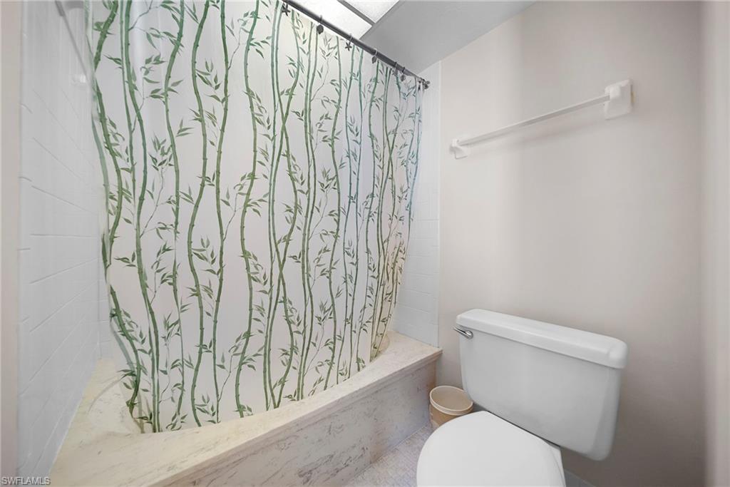26300 Hickory Boulevard, Unit 503 Bonita Springs, FL 34134 - Photo 29 of 50 Bathroom featuring toilet and shower / bath combo with shower curtain