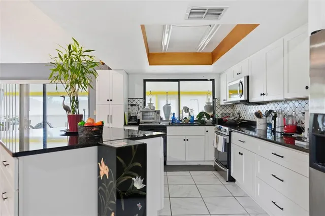 a kitchen with stainless steel appliances granite countertop a stove a sink and a refrigerator