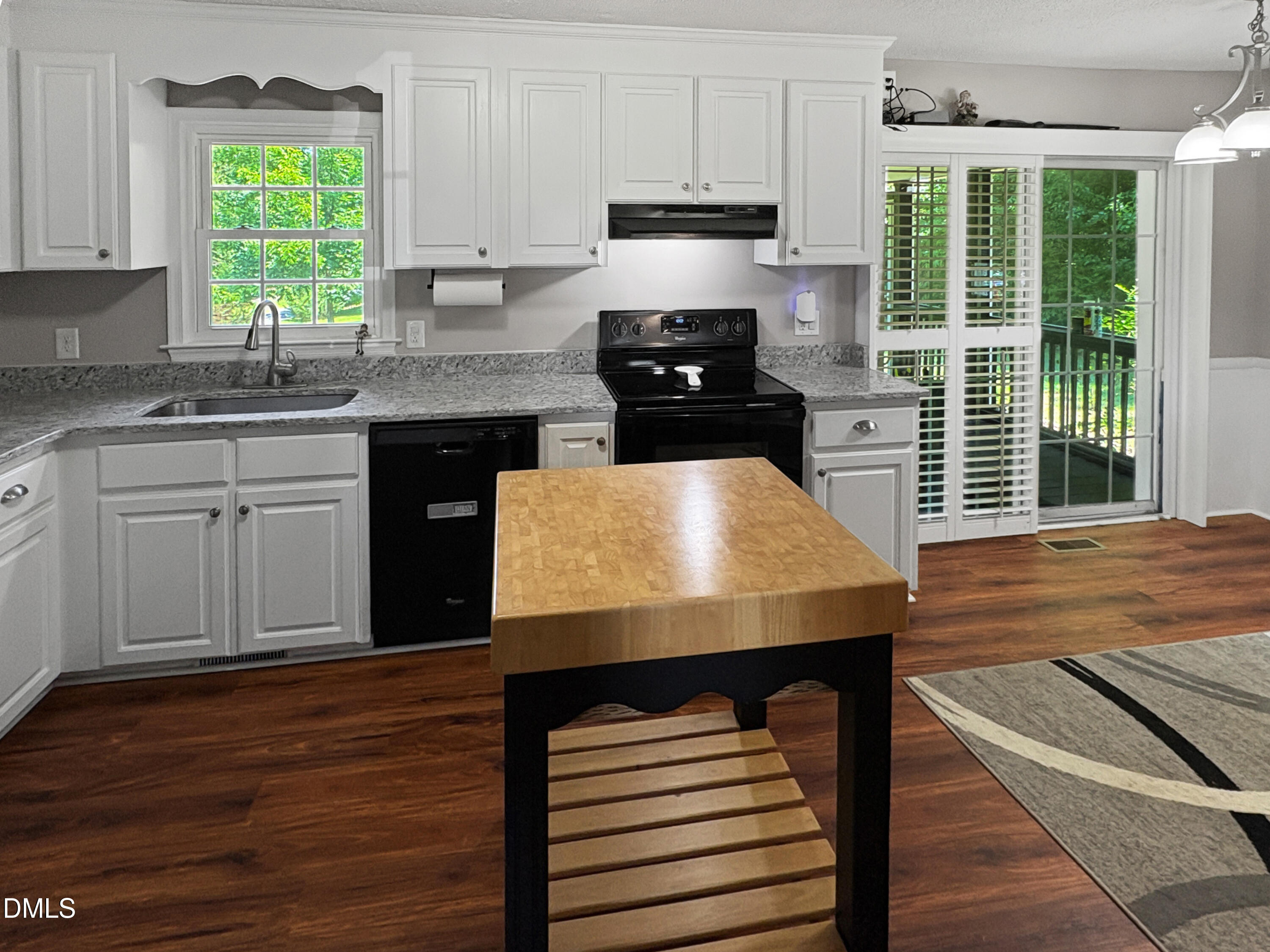 573 Arnold Road Louisburg, NC 27549 - Photo 7 of 16 a kitchen with wooden floors wooden cabinets a sink and a window