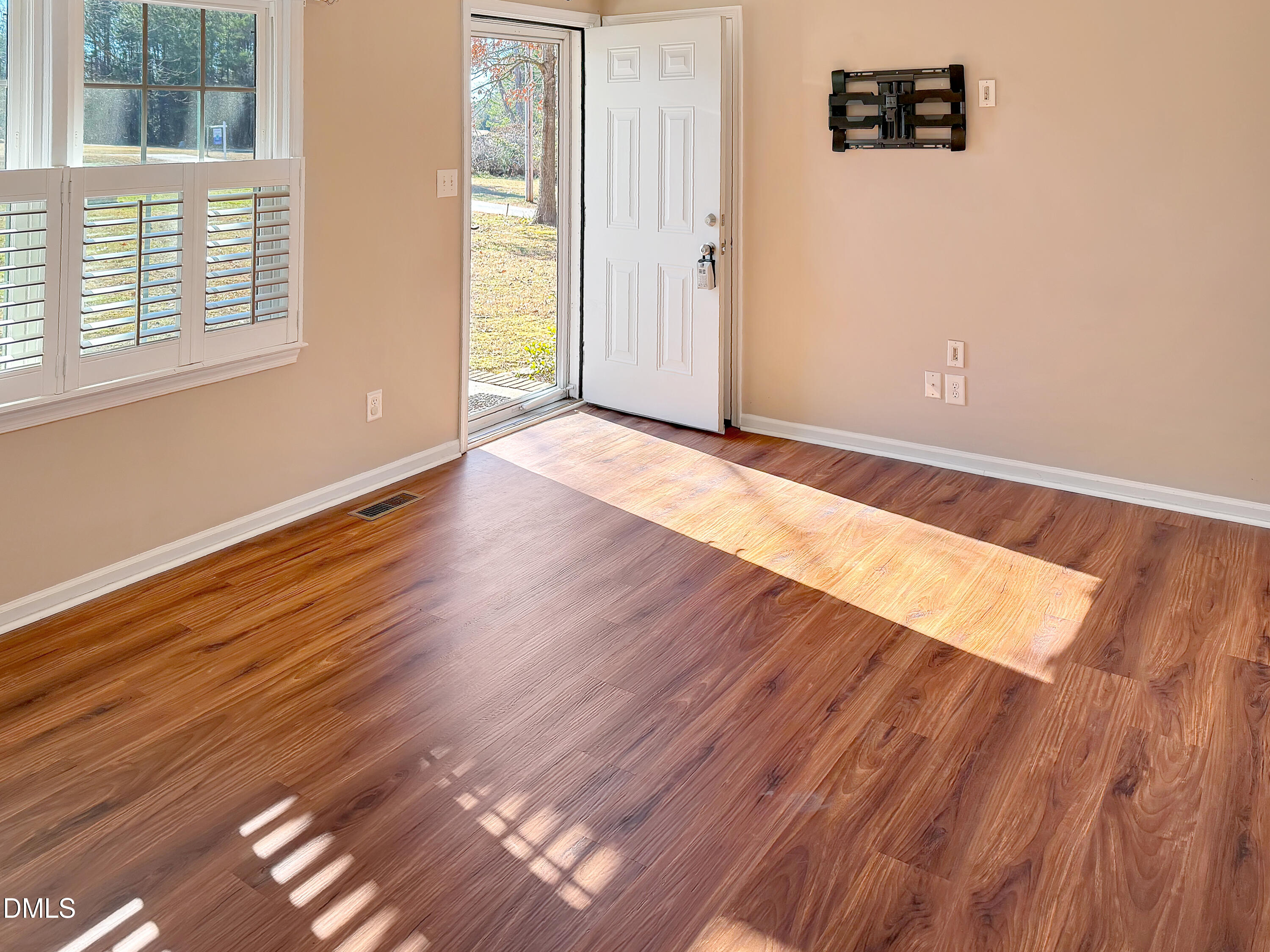 573 Arnold Road Louisburg, NC 27549 - Photo 8 of 16 an empty room with wooden floor and windows