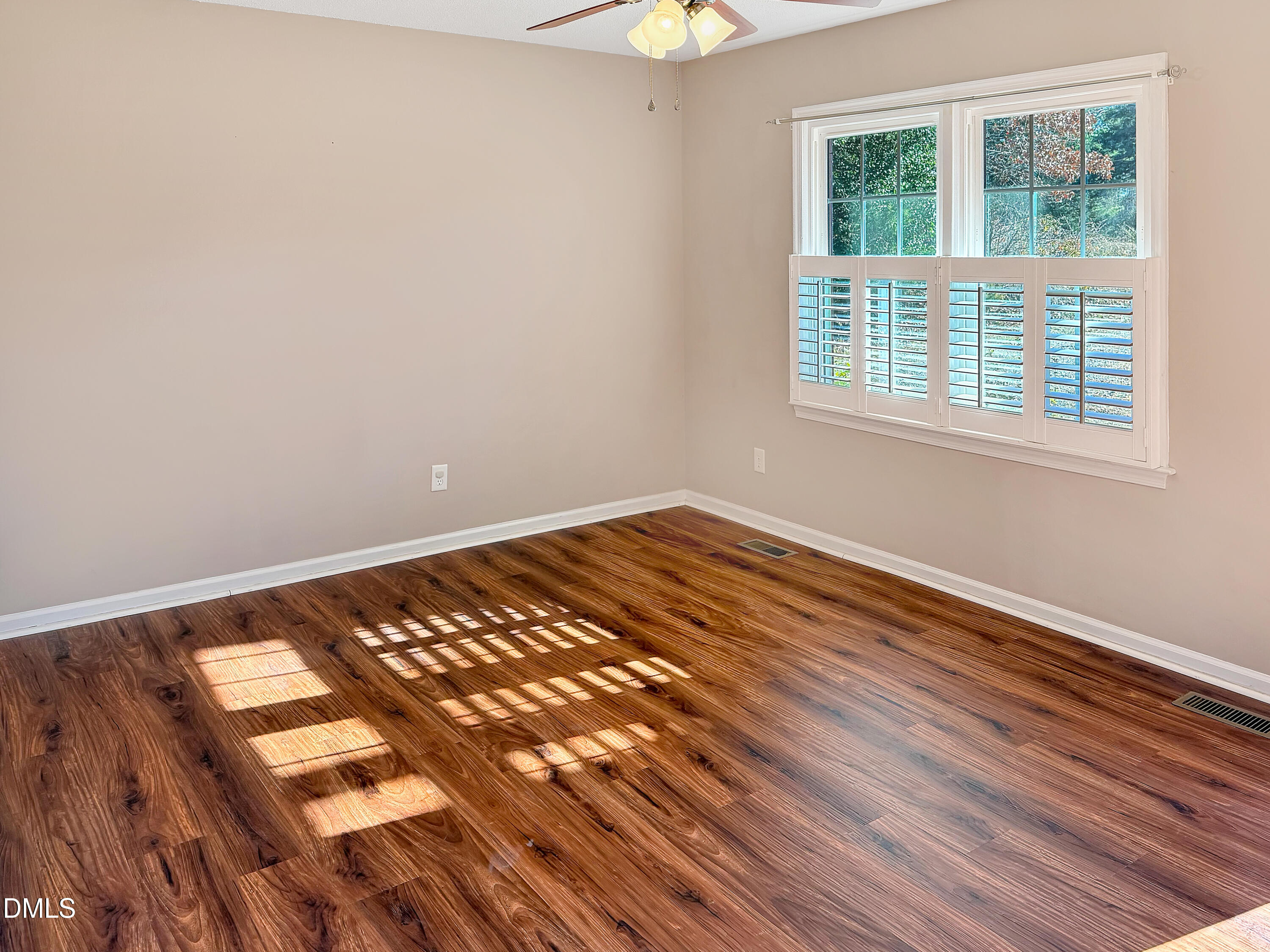 573 Arnold Road Louisburg, NC 27549 - Photo 10 of 16 an empty room with wooden floor and windows