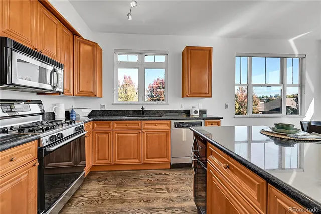 a kitchen with stainless steel appliances granite countertop a stove sink and cabinets