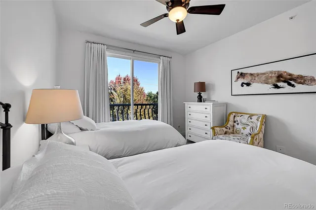 a bedroom with two beds and a chandelier