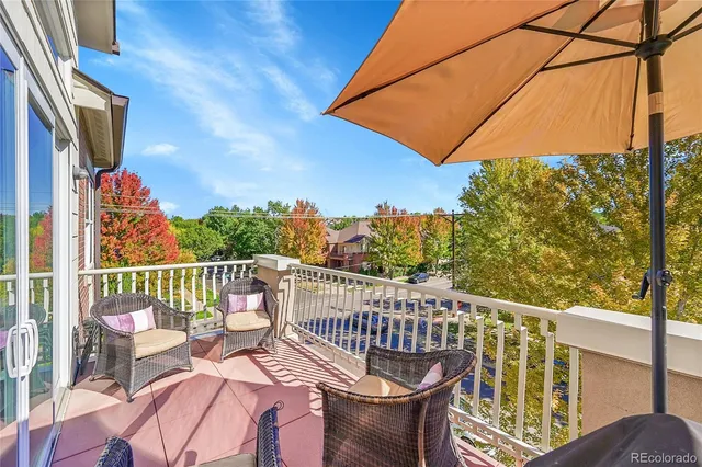 a view of a balcony with wooden floor and outdoor seating