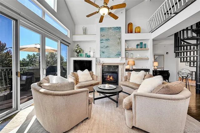 a living room with furniture a fireplace and a floor to ceiling window