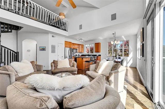 a living room with furniture kitchen view and a large window
