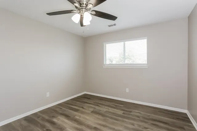 wooden floor in an empty room with a window