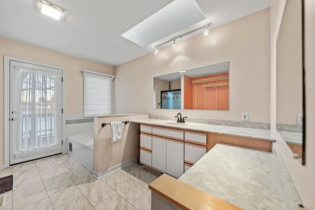 a large bathroom with a sink a large mirror and a bathtub