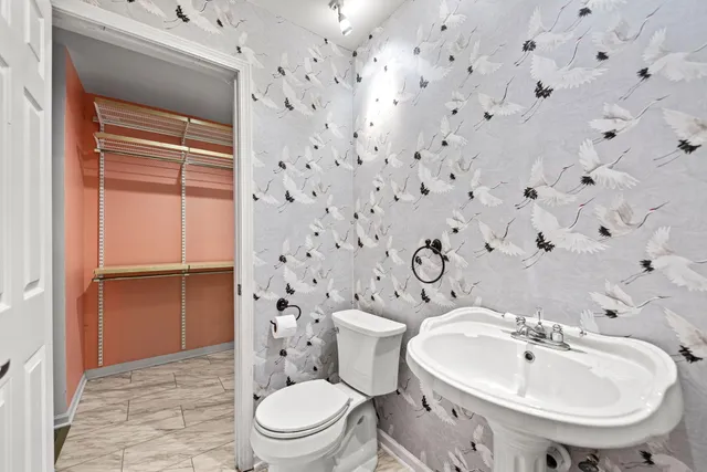 a white toilet sitting next to a bathroom sink