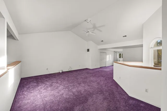 a view of a big room with wooden floor and ceiling fan