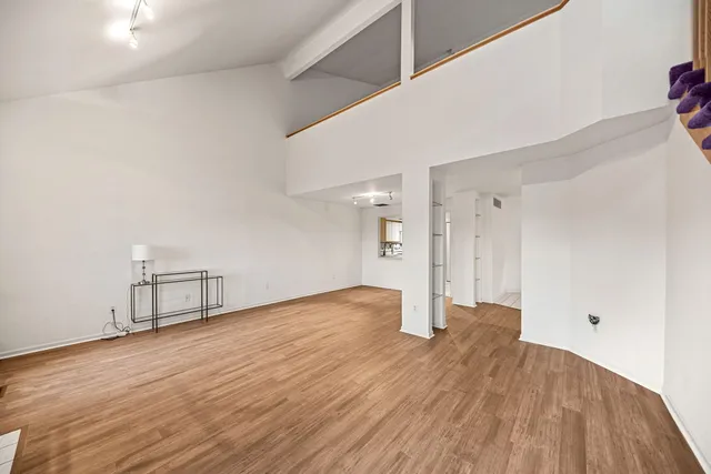 a view of empty room with wooden floor